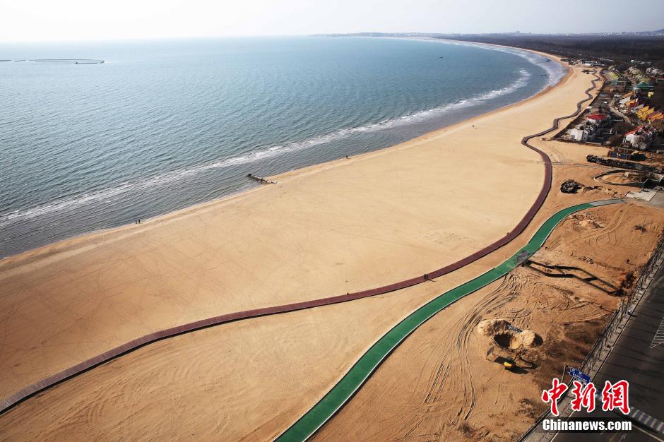 3月13日，秦皇島萬(wàn)米臨海沙灘木棧道。據(jù)了解，該木棧道全長(zhǎng)約4200米，與北戴河區(qū)原有的7500米木棧道對(duì)接后全線總長(zhǎng)度1.17萬(wàn)米，整個(gè)木棧道東起秦皇島體育基地游船碼頭，西至北戴河濕地公園，呈波浪形蜿蜒10.4公里海岸線。 中新社發(fā) 曹建雄 攝 CNSPHOTO